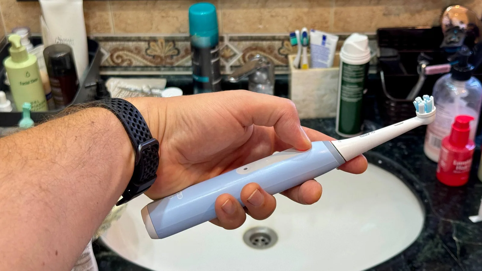 elektrisk tannbørste fra Oral-B iO holdt i hånden på badet